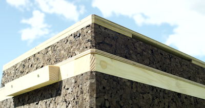 Bienenstock aus Kork und Holz im Freien vor blauem Himmel