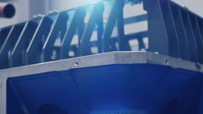 Blaue Industrieanlage aus Stahl mit montierter Metallplatte unter hellem Scheinwerferlicht