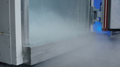 Dichter Nebel quillt aus der geöffneten Tür einer industriellen Prüfkammer