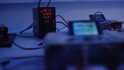 Digitales Labornetzteil mit roter LED Anzeige und Kabelverbindungen auf einem Prüfstand