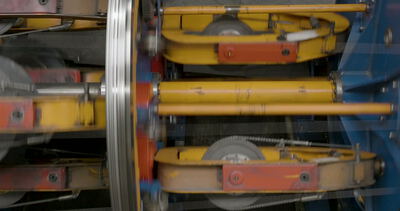 Draufsicht auf eine rotierende Korbverseilmaschine bei der Produktion von Stahlseilen