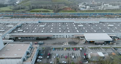 Drohnenaufnahme von einer großen Industriehalle mit Photovoltaikanlage auf dem Dach