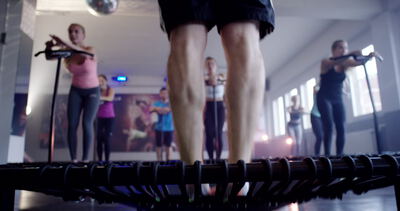 Dynamischer Fitnesskurs: Gruppe beim Jumping-Fitness-Training auf kleinen Trampolinen