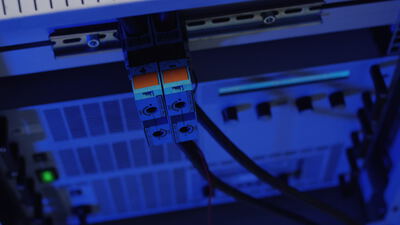 Elektronische Bauteile mit Kabelverbindungen in einem Serverschrank bei blauem Licht