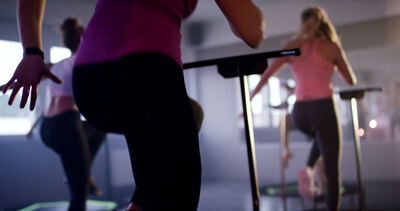 Gruppe von Frauen beim synchronen Fitnesstraining auf kleinen Trampolinen im Studio