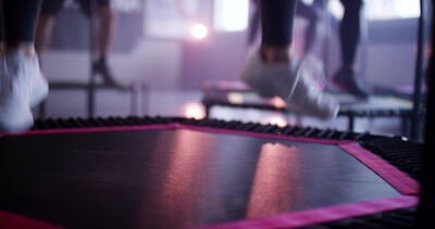 Gruppe von Personen beim synchronen Fitnesstraining auf kleinen Trampolinen