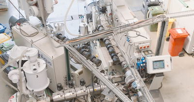 Industrielle Extrusionsanlage in einer Fabrikhalle zur Kunststoffverarbeitung in der Draufsicht