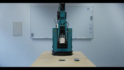 Industrieller Gelenkarmroboter auf Holztisch führt präzise Drehbewegungen in einem hellen Laborraum vor Whiteboard aus