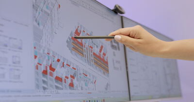 Ingenieurin erläutert eine komplexe 3D-CAD-Planung für ein Gebäudeprojekt am Bildschirm