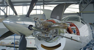 Nahaufnahme eines geöffneten Turboprop-Triebwerks an einem Flugzeug zur technischen Wartung im Hangar: Flugzeug, Triebwerk