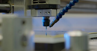Nahaufnahme eines präzisen CNC-Fräskopfes bei der automatisierten Bearbeitung einer Kunststoffoberfläche