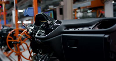 Nahaufnahme eines vormontierten Auto-Armaturenbretts auf einer industriellen Fertigungsstraße