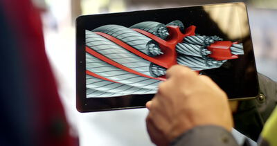 Person bedient ein Tablet mit einer dreidimensionalen Darstellung eines technischen Drahtseils