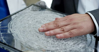 Prüfung einer zerbrochenen Glasscheibe mit kreisförmigem Bruchmuster