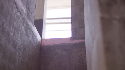 Rohe Betonwände an einer Ecke mit hellem Fenster im Innenraum