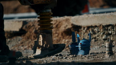 Vibrationsstampfer verdichtet Schotter auf einer Gleisbaustelle
