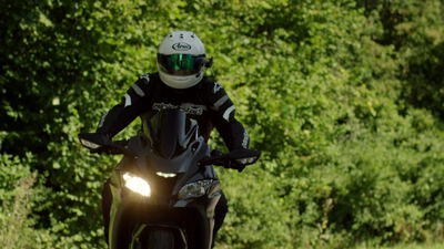 Motorradfahrer fährt auf einem Sportmotorrad über eine Landstraße