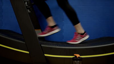Beine laufen auf einem gebogenen Laufband im Fitnessstudio