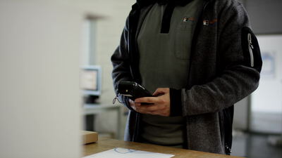 Mitarbeiter scannt ein Paket mit einem Handscanner im Warenlager