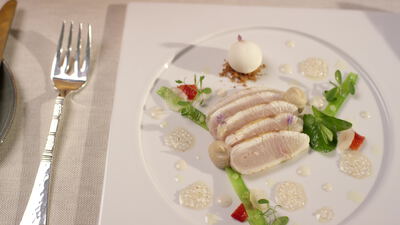 Tranchiertes Geflügel mit essbarer Blüte auf weißem Teller Tranchiertes Geflügel mit essbarer Blüte auf weißem Teller, Gourmet Teller, gehobene Küche und pochiertes Geflügel als 4K