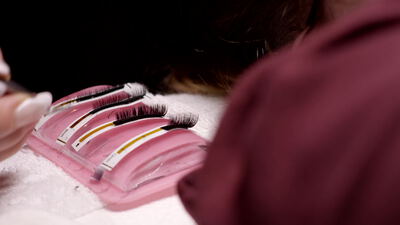 Wimpernverlängerung im Kosmetikstudio bei entspannter Kundin, Wimpernextensions, Wimpern kleben und Kosmetikerin bei der