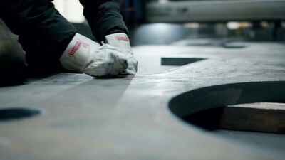 Arbeiter bearbeitet eine große Stahlplatte in der Metallverarbeitung