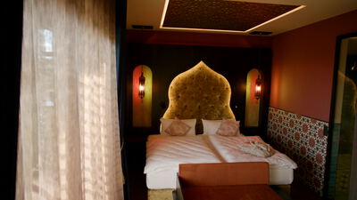 Orientalisches Hotelzimmer mit verziertem Bettkopfteil und Laternen Orientalisches Hotelzimmer mit verziertem Bettkopfteil und Laternen, marokkanisches Schlafzimmer, Hotelzimmer Luxus und
