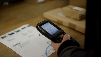 Mobiler Handscanner erfasst einen Lieferschein im Wareneingang