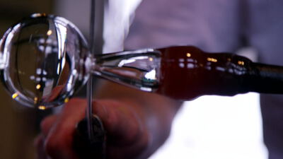 Rotwein wird aus der Flasche in ein geneigtes Glas gefüllt Rotwein wird aus der Flasche in ein geneigtes Glas gefüllt, Rotwein Video lizenzfrei, Wein einschenken Aufnahmen kaufen und