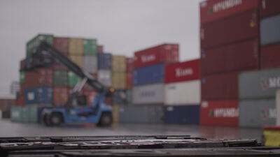 Containerstapler bewegt Container im regnerischen Hafendepot: Containerstapler, Reachstacker