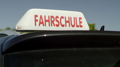 Fahrschulschild auf einem Autodach vor blauem Himmel Fahrschulschild auf einem Autodach vor blauem Himmel, Fahrschule, Fahrschulauto und Fahrschulwagen als 4K Stockvideo