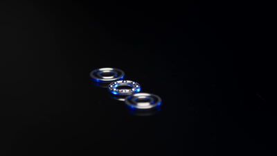 Drei Kugellager mit blauer Dichtung auf dunkler Spiegelfläche Drei Kugellager mit blauer Dichtung auf dunkler Spiegelfläche, Wälzlager, Rillenkugellager und Maschinenteil als 4K