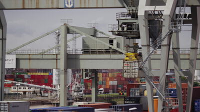 Ein Portalkran hebt einen Container im geschäftigen Containerhafen