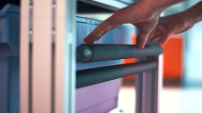 Eine Hand umfasst den gepolsterten Haltegriff eines Fitnessgeräts
