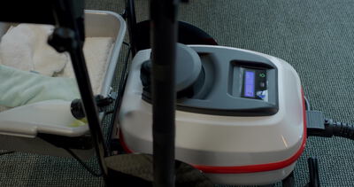 Kosmetikgerät mit Display steht bereit auf der Behandlungsliege im Studio