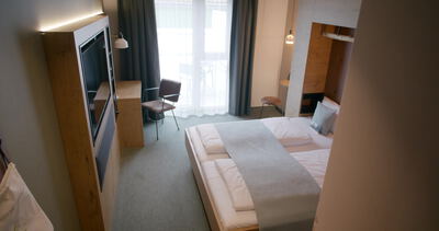 Kamerafahrt am Spiegel vorbei enthüllt komplettes Hotelzimmer mit Betten