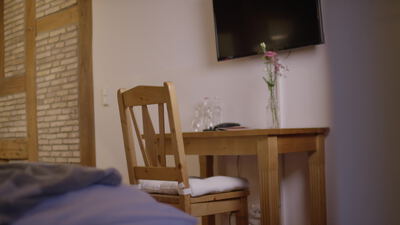 Gemütliches Hotelzimmer mit Holztisch und gemachtem Bett