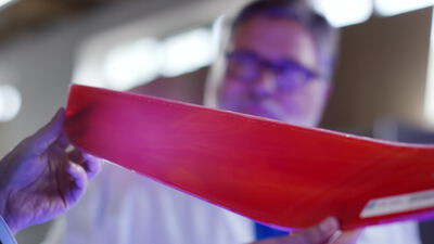 Wissenschaftler prüft flexible rote Polymerfolie im Labor