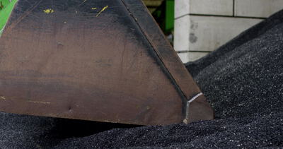 Metallschaufel in einem Haufen aus schwarzem Gummigranulat
