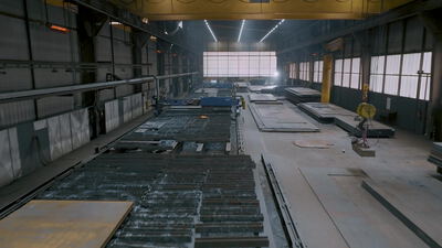 Brennschneidanlage bearbeitet Stahlplatten in einer großen Werkshalle