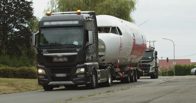 Schwertransporter zieht einen Flugzeugrumpf auf einem Tieflader