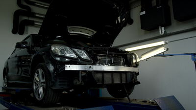 Schwarzes Auto auf der Hebebühne in der Autowerkstatt