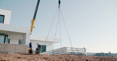 Baukran hebt Betonfertigteil auf moderne Baustelle