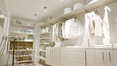 Helles Ankleidezimmer mit weißen Blusen und Schuhregal, begehbarer Kleiderschrank, Ankleidezimmer Aufnahmen lizenzfrei und