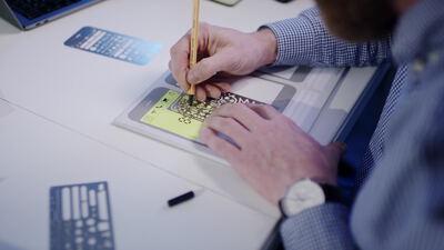 Ingenieur zeichnet mit Bleistift und Schablone auf Papier