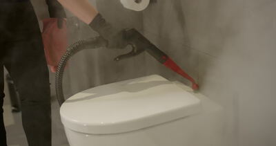 Dampfreiniger desinfiziert Toilette mit dichtem Wasserdampf