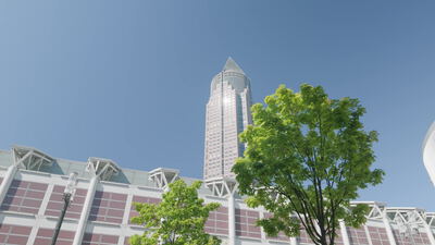 Messeturm Frankfurt mit Pyramidenspitze hinter grünen Bäumen