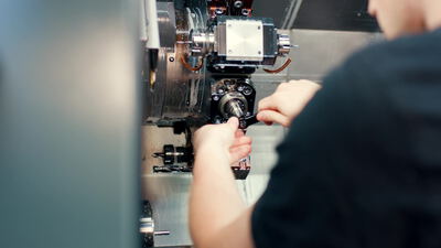 Facharbeiter rüstet ein Werkzeug an einer CNC Drehmaschine ein, cnc drehmaschine einrichten, facharbeiter an der maschine
