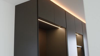 Moderner dunkler Einbauschrank mit warmer LED Beleuchtung