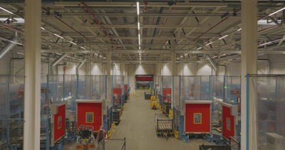 Symmetrischer Blick durch eine Produktionshalle mit Roboterzellen